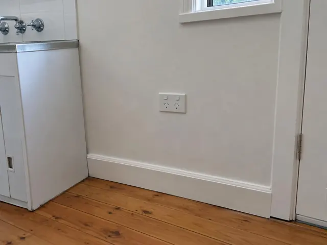White double power point on a painted interior wall above timber floorboards in a home in Artarmon