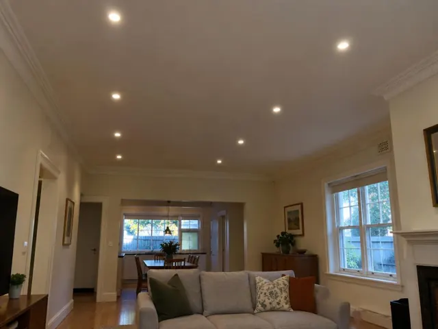 Ceiling with recessed downlights above a living and dining room with cream walls and timber floors in Lane Cove